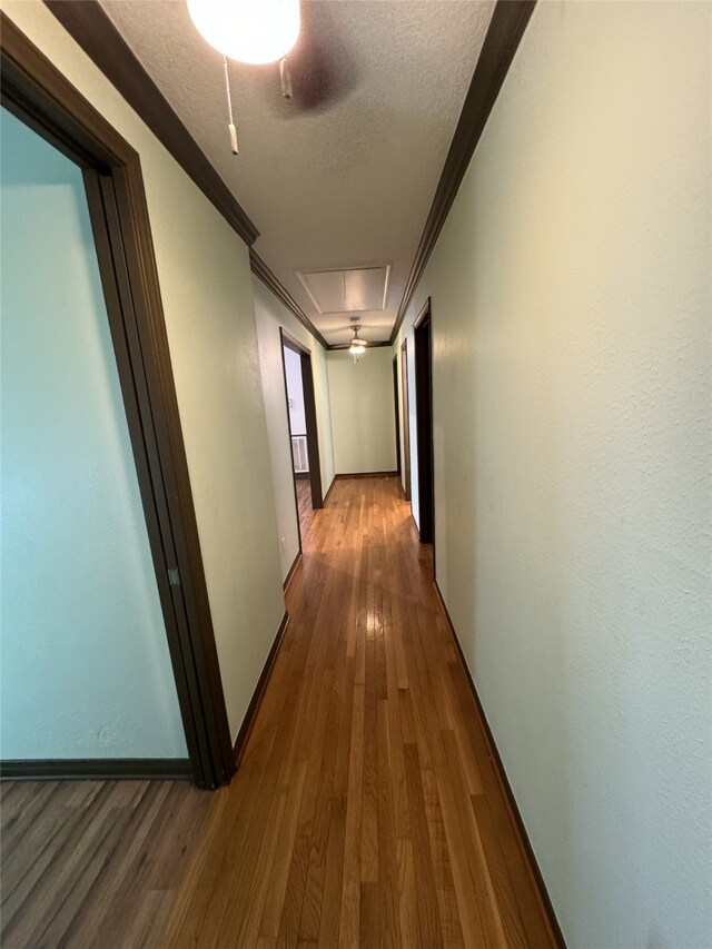 20706 Northcreek Ln, Houston, TX 77073 - corridor with attic access, ornamental molding, wood finished floors, a textured ceiling, and baseboards