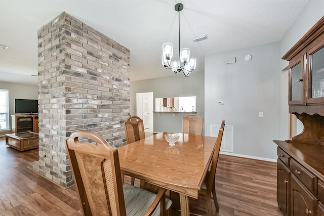 dining area with dark wood-style flooring, a chandelier, and baseboards