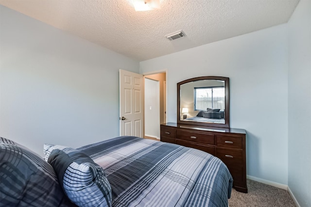 bedroom featuring light colored carpet, baseboards, and a textured ceiling