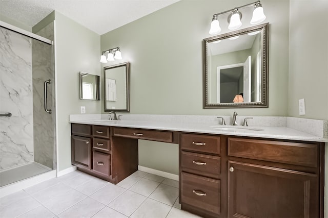 bathroom with a marble finish shower, double vanity, baseboards, and tile patterned flooring