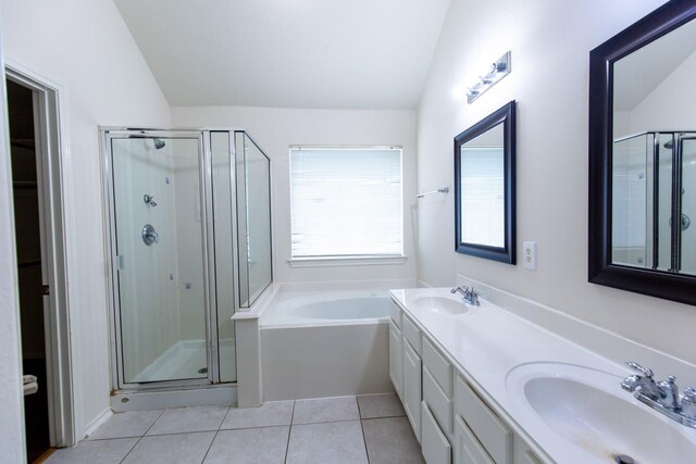 bathroom with a stall shower, vaulted ceiling, tile patterned floors, a garden tub, and double vanity