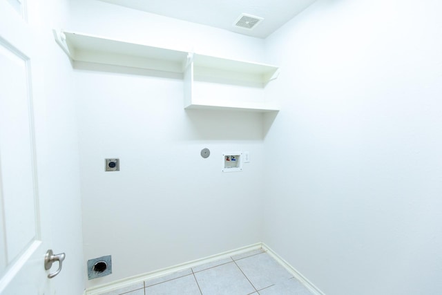 laundry room featuring electric dryer hookup, hookup for a washing machine, light tile patterned floors, and baseboards