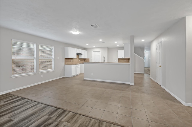 14418 Cellini Dr, Cypress, TX 77429 - unfurnished living room with light tile patterned floors, baseboards, recessed lighting, and a sink