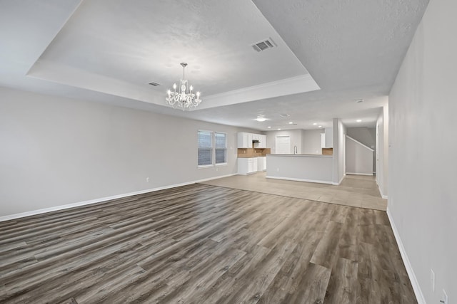 14418 Cellini Dr, Cypress, TX 77429 - unfurnished living room with a tray ceiling, wood finished floors, baseboards, a chandelier, and recessed lighting