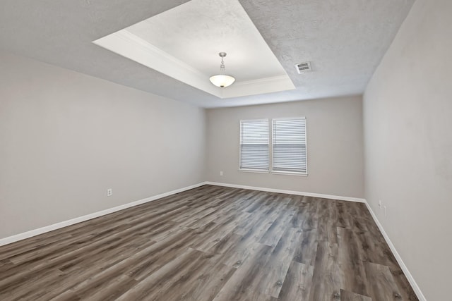 14418 Cellini Dr, Cypress, TX 77429 - spare room with a tray ceiling, dark wood finished floors, baseboards, ornamental molding, and a textured ceiling