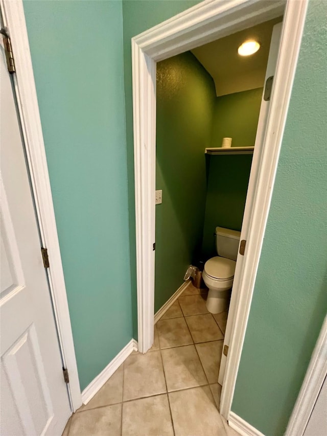 bathroom featuring tile patterned flooring, toilet, and baseboards