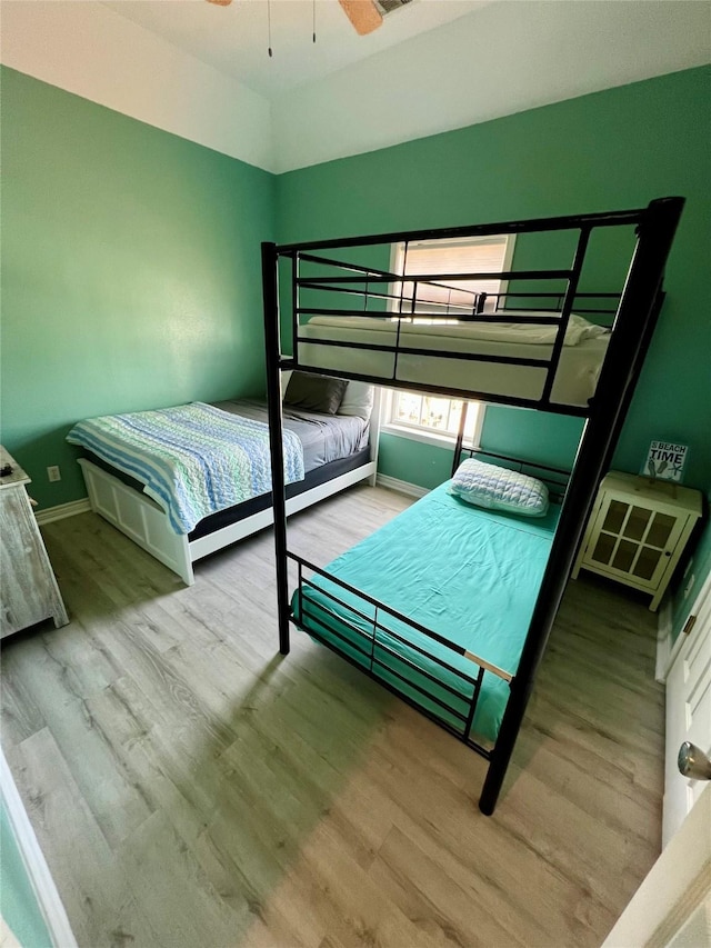 bedroom with baseboards and wood finished floors