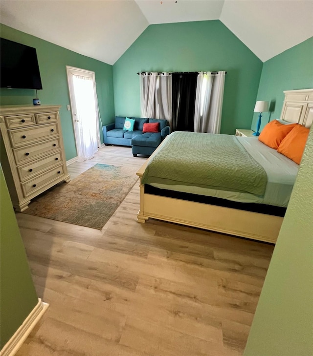 bedroom featuring lofted ceiling and wood finished floors