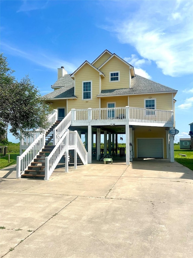 view of front of house with a carport, a shingled roof, concrete driveway, and a garage