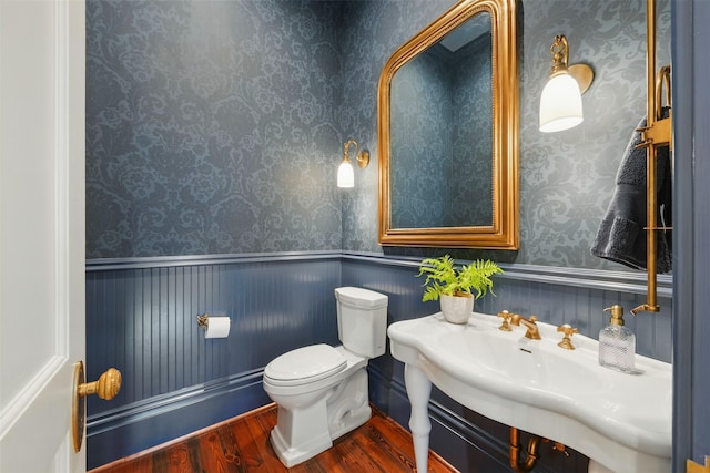 215 Bayland Ave, Houston, TX 77009 - bathroom featuring wood finished floors, toilet, a sink, and wallpapered walls