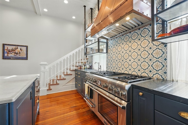 215 Bayland Ave, Houston, TX 77009 - kitchen featuring double oven range, custom exhaust hood, wood finished floors, decorative backsplash, and a sink