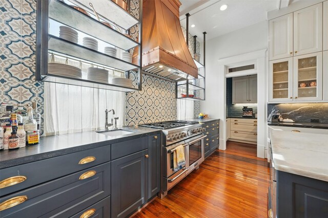 215 Bayland Ave, Houston, TX 77009 - kitchen featuring double oven range, a sink, custom range hood, tasteful backsplash, and dark wood-style floors