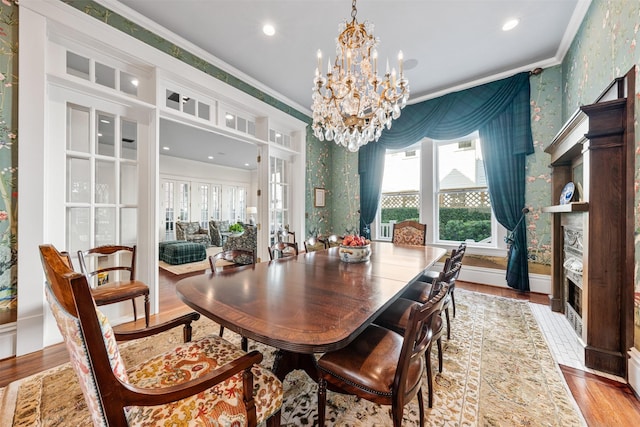 215 Bayland Ave, Houston, TX 77009 - dining room with wallpapered walls, ornamental molding, a chandelier, wood finished floors, and baseboards