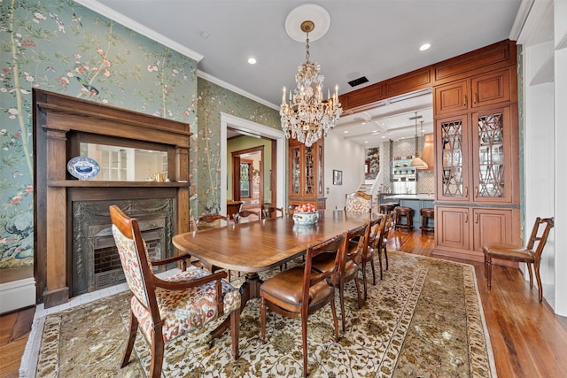 215 Bayland Ave, Houston, TX 77009 - dining room featuring stairs, wood finished floors, a chandelier, a premium fireplace, and crown molding