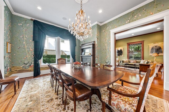 215 Bayland Ave, Houston, TX 77009 - dining space with crown molding, wallpapered walls, wood finished floors, healthy amount of natural light, and a chandelier