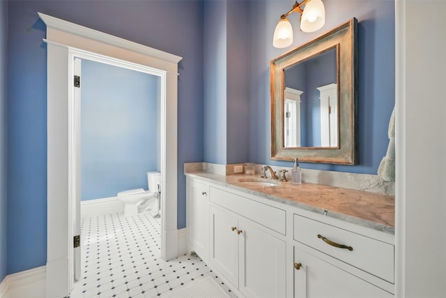 215 Bayland Ave, Houston, TX 77009 - bathroom featuring toilet, vanity, tile patterned floors, and baseboards