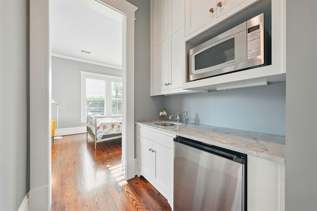 215 Bayland Ave, Houston, TX 77009 - indoor wet bar with stainless steel microwave, dark wood-style floors, fridge, crown molding, and dishwashing machine