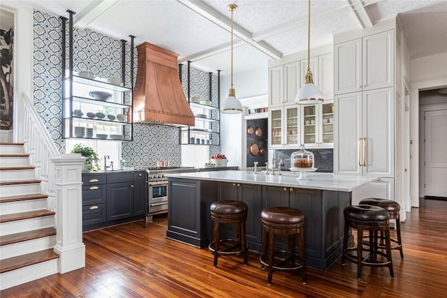 215 Bayland Ave, Houston, TX 77009 - kitchen featuring coffered ceiling, decorative backsplash, dark wood finished floors, stainless steel stove, and glass insert cabinets