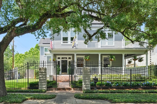 215 Bayland Ave, Houston, TX 77009 - view of front of home with covered porch, a balcony, solar panels, and a fenced front yard
