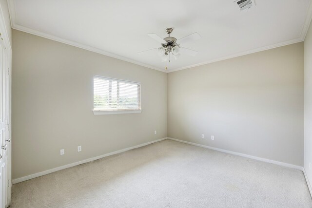 empty room with light colored carpet, baseboards, crown molding, and ceiling fan
