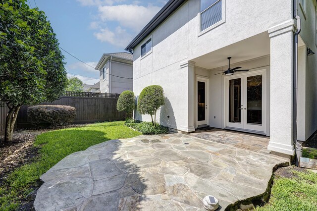 view of patio with french doors, fence, and a ceiling fan