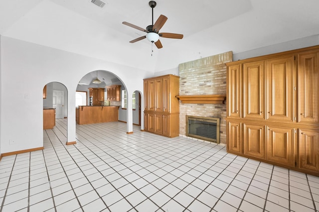 1803 Quiet Country Ct, Houston, TX 77345 - unfurnished living room with a ceiling fan, a large fireplace, light tile patterned flooring, arched walkways, and baseboards