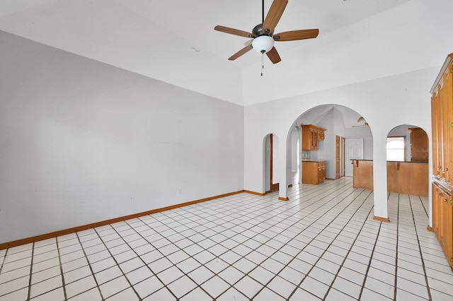 1803 Quiet Country Ct, Houston, TX 77345 - unfurnished living room with a ceiling fan, high vaulted ceiling, light tile patterned floors, arched walkways, and baseboards