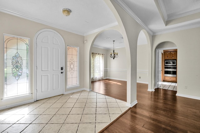 1803 Quiet Country Ct, Houston, TX 77345 - entrance foyer featuring a chandelier, wood finished floors, crown molding, arched walkways, and baseboards