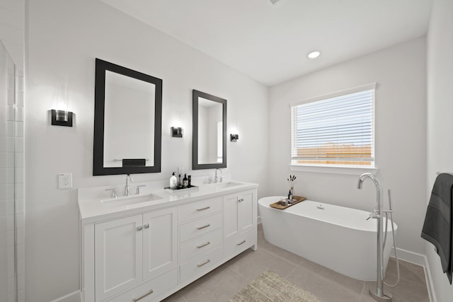 21250 Blue Bluff Dr, Cypress, TX 77433 - full bathroom with a freestanding bath, double vanity, tile patterned flooring, and baseboards