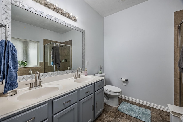 full bath with a stall shower, toilet, double vanity, stone finish flooring, and baseboards