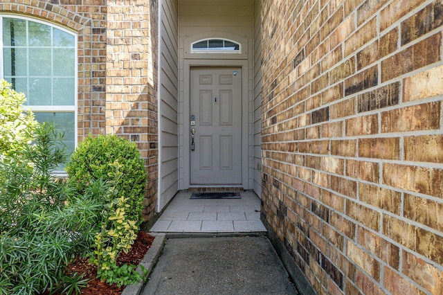 doorway to property featuring brick siding