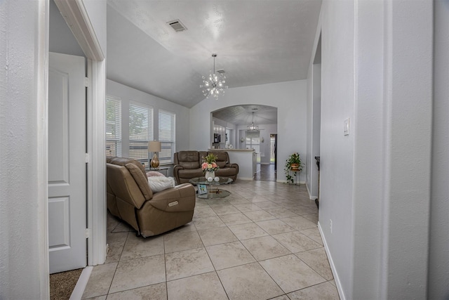 living room featuring arched walkways, lofted ceiling, a chandelier, light tile patterned floors, and baseboards
