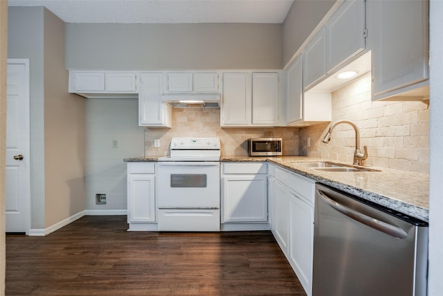kitchen with stainless steel appliances, a sink, under cabinet range hood, light stone counters, and tasteful backsplash