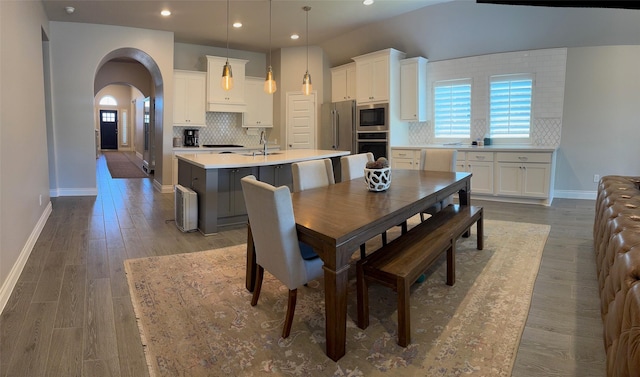 7010 Goldstrum Way, Katy, TX 77493 - dining area featuring baseboards, recessed lighting, arched walkways, and wood finished floors