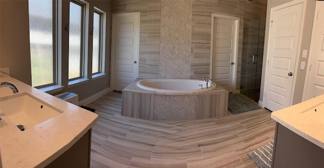 7010 Goldstrum Way, Katy, TX 77493 - bathroom featuring double vanity, a garden tub, a stall shower, and baseboards
