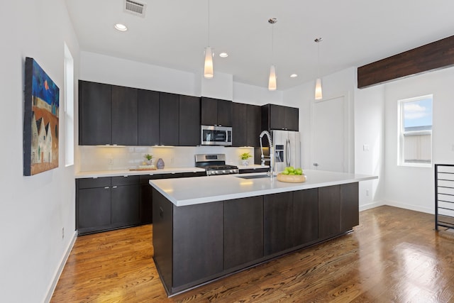 910 W 19th St Unit A, Houston, TX 77008 - kitchen with stainless steel appliances, light countertops, baseboards, a sink, and a kitchen island with sink