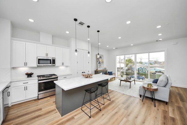 1218 English St, Houston, TX 77009 - kitchen featuring appliances with stainless steel finishes, recessed lighting, white cabinets, tasteful backsplash, and light wood-style flooring
