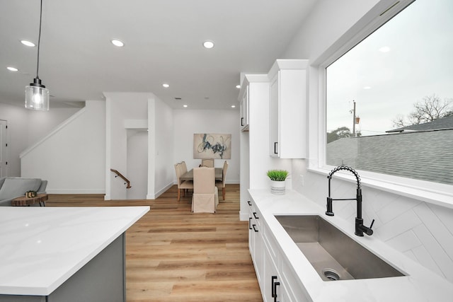 1218 English St, Houston, TX 77009 - kitchen with a sink, white cabinetry, light countertops, recessed lighting, and light wood-style flooring