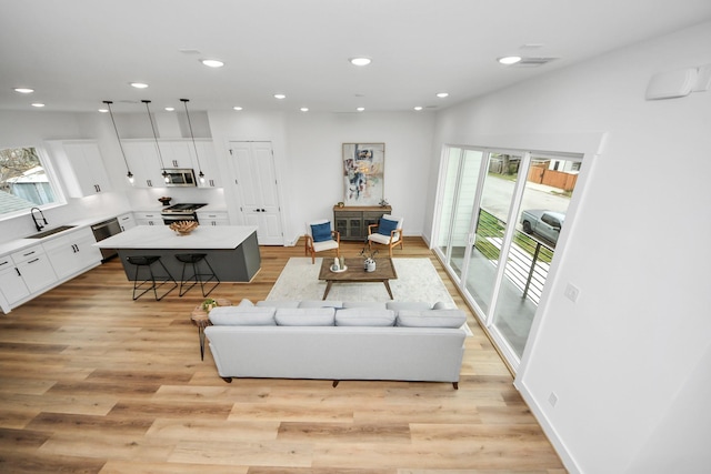 1218 English St, Houston, TX 77009 - living room featuring light wood finished floors and recessed lighting