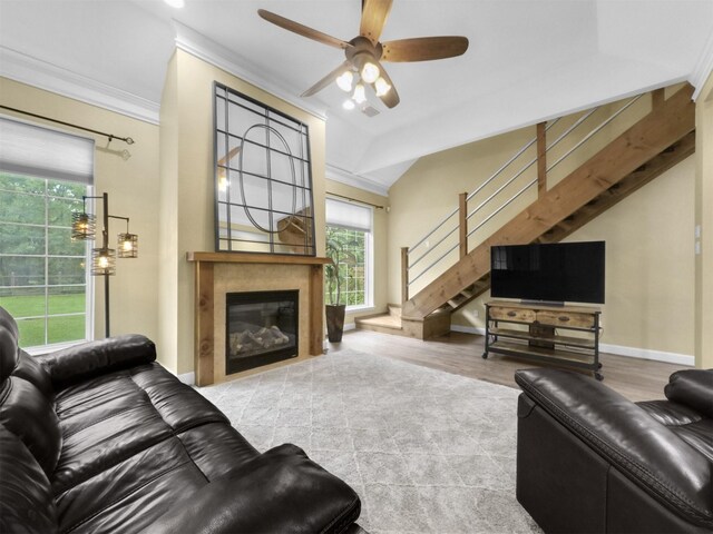 11987 White Oak Xing, Conroe, TX 77385 - living area featuring stairway, a ceiling fan, a glass covered fireplace, crown molding, and wood finished floors