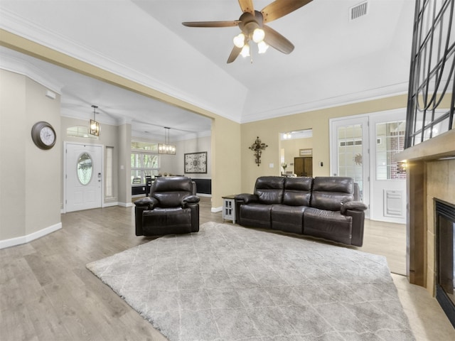 11987 White Oak Xing, Conroe, TX 77385 - living room with a fireplace, wood finished floors, ceiling fan, crown molding, and a chandelier