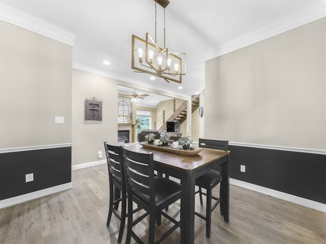 11987 White Oak Xing, Conroe, TX 77385 - dining space featuring ornamental molding, wood finished floors, a chandelier, baseboards, and a fireplace