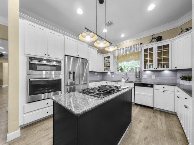 11987 White Oak Xing, Conroe, TX 77385 - kitchen featuring stainless steel appliances, light wood-type flooring, decorative backsplash, a sink, and crown molding