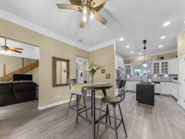 11987 White Oak Xing, Conroe, TX 77385 - dining space with ceiling fan, ornamental molding, light wood-style floors, recessed lighting, and baseboards
