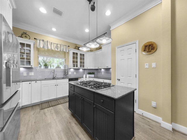 11987 White Oak Xing, Conroe, TX 77385 - kitchen featuring stovetop with downdraft, crown molding, backsplash, stainless steel refrigerator with ice dispenser, and white cabinets