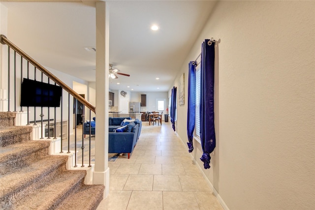 hallway with stairway, light tile patterned floors, baseboards, and recessed lighting