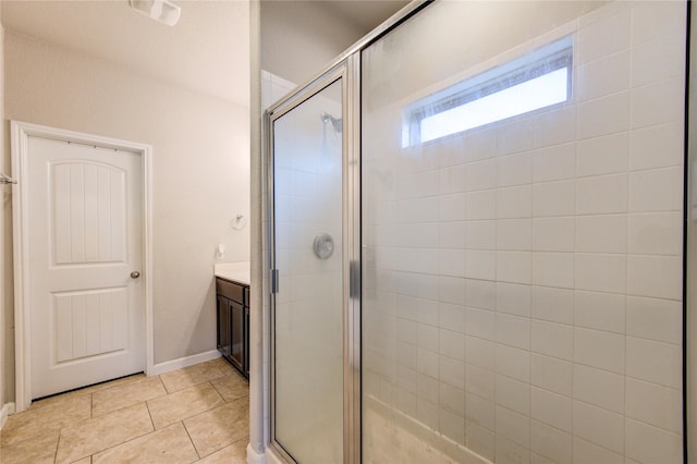 bathroom with a shower stall, tile patterned floors, vanity, and baseboards