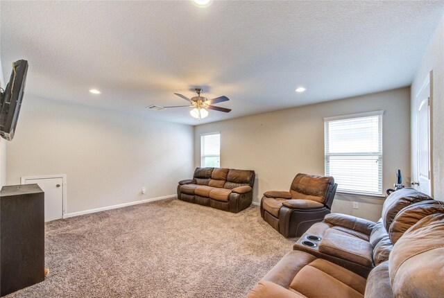 carpeted living area featuring a ceiling fan, recessed lighting, baseboards, and a textured ceiling