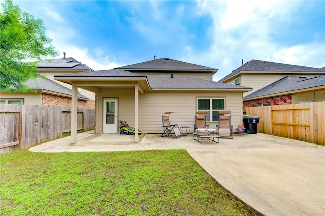 back of property with a patio area and roof with shingles