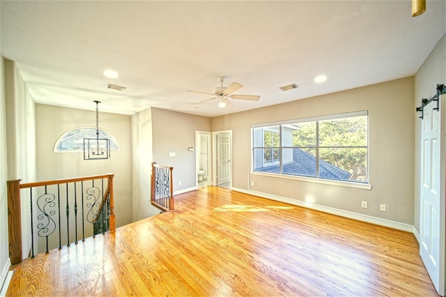 910 Peachwood Bend Dr, Houston, TX 77077 - empty room featuring wood finished floors, baseboards, ceiling fan, a barn door, and recessed lighting